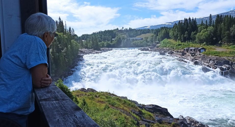 noordkaap_persoon_kijkt_stroomversnelling_laksfossen_013